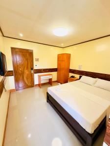 a bedroom with a large white bed in a room at Arron Grand Inn in Zamboanga