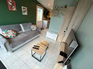 a living room with a couch and a table at Le Petit Studio de Merlimont in Merlimont