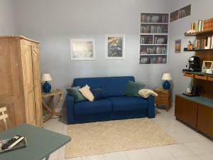 a living room with a blue couch and bookshelves at Casa Diana in Tarquinia