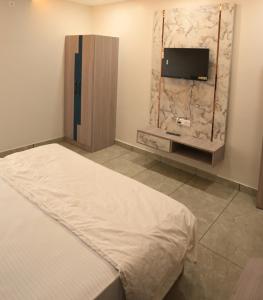 a bedroom with a bed and a flat screen tv at Mithila Resort in Jāmb