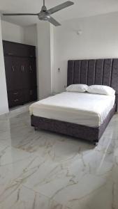a bedroom with a large bed with a ceiling fan at Edificio Torre in Barrancabermeja