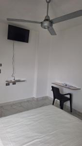 a ceiling fan in a room with a table and a chair at Edificio Torre in Barrancabermeja +3 photos