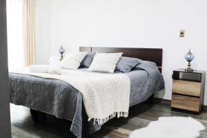 a bedroom with a bed with pillows on it at Casa Grande con Tinaja a 10 minutos de Lago Puyehue y Rupanco Ruta 215 Internacional in Puyehue