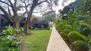 a walkway in front of a building with trees and plants at Hotel CLN in Copacabana