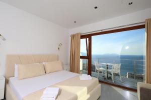 a bedroom with a bed and a balcony with a table at Hill Suites in Vlorë +95 photos