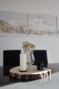 a candle and a vase on a wooden table at Appartement 3 chambres - 100m2 - Jacuzzi in Les Deux Alpes