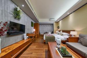 a hotel room with a bed and a couch at Guangzhou Bokeshijia Hotel in Guangzhou