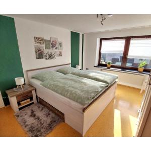 a bedroom with a bed in a room with a window at Ferienwohnung Eifelherzen in Demerath