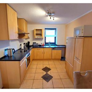 a small kitchen with wooden cabinets and a window at Ferienwohnung Eifelherzen in Demerath +17 photos
