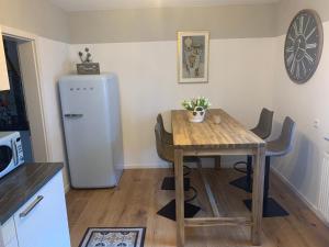 a kitchen with a wooden table and a refrigerator at Carpe diem in Speyer