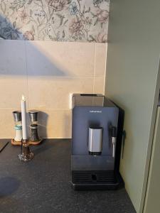 a coffee maker sitting on a counter with a candle at Skolmästarevägen Åldersgräns 30 in Falun