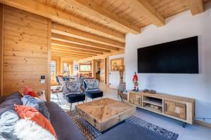 a living room with a large flat screen tv at Chalet BO'M in Le Grand-Bornand