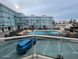 a blue car parked in a parking lot in front of a building at La Cenia in Denia