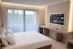 a hotel room with a bed and a television at Belenus Thermalhotel in Zalakaros