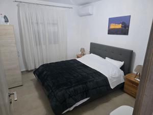 a bedroom with a large bed with a black blanket at uncie spiros house in Nea Fokea