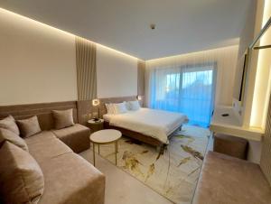 a hotel room with a bed and a couch at Belenus Thermalhotel in Zalakaros