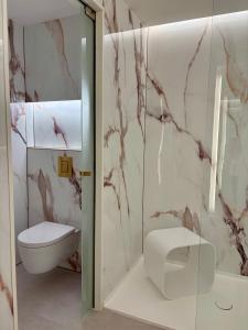 a bathroom with a toilet and a glass shower door at Belenus Thermalhotel in Zalakaros