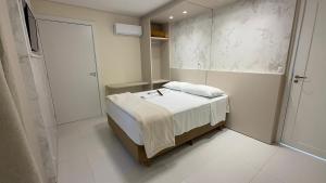 ein kleines Schlafzimmer mit einem Bett und einem Spiegel in der Unterkunft Hotel Maichel in Erval Velho