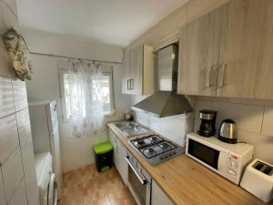 a small kitchen with a stove and a microwave at La Cenia in Denia