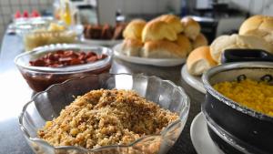 a table topped with different types of food in bowls at Hotel Pousada Positiva in Itabuna