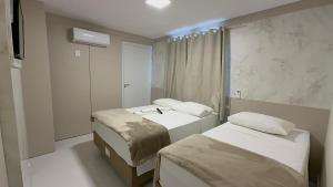 ein Zimmer mit zwei Betten und einem Waschbecken in der Unterkunft Hotel Maichel in Erval Velho
