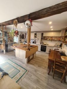 a large kitchen with a table and a dining room at Maison Maisy in Navarrenx