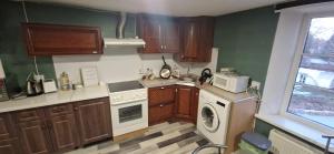 a kitchen with a washing machine and a microwave at Attic rooms-Bēniņu istabas in Jelgava