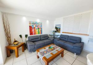 a living room with two blue couches and a table at Beachfront view Condo beside la Isla Mall in Puerto Vallarta