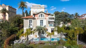 a house with a swimming pool in front of it at Villa Blue Riviera & Le Joyau de la baie de Cannes in Cannes