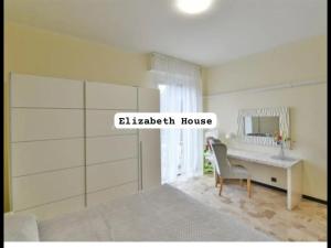 a bedroom with a bed and a desk with a mirror at Elizabeth House in Como