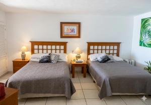a bedroom with two beds and a table with lamps at Beachfront view Condo beside la Isla Mall in Puerto Vallarta +11 photos