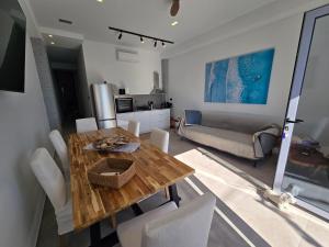 a living room with a wooden table and white chairs at Ilia Suites "Thalassa" in Ilia