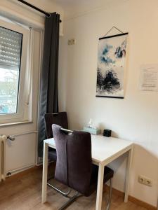 a desk and chairs in a room with a window at Chambre double à Niederkorn in Differdange