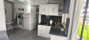 a kitchen with white cabinets and a sink and a stove at γαληνη in Vamos