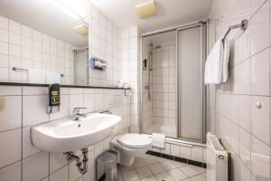 a bathroom with a sink and a toilet and a shower at Raststättenhotel Tecklenburger Land West in Tecklenburg +52 photos