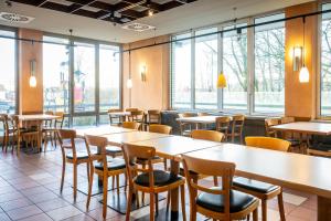 a restaurant with tables and chairs and windows at Raststättenhotel Tecklenburger Land West in Tecklenburg