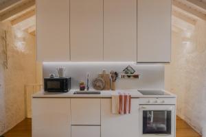 a kitchen with white cabinets and a microwave at Bravia Country House in Fafião