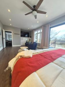 a bedroom with a large bed with a ceiling fan at Picturesque Luxury Waterside Villa in Niagara Falls +75 photos