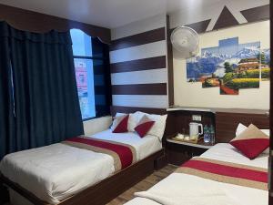 a hotel room with two beds and a window at Hotel Atithi in Surkhet