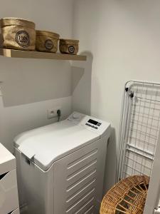 a small white refrigerator in a kitchen with a shelf at Agréable maison avec SPA in Crécy-en-Ponthieu +18 photos