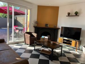 a living room with a fireplace and a tv at Agréable maison avec SPA in Crécy-en-Ponthieu