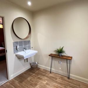 a bathroom with a sink and a mirror on the wall at Hues - Castle Cary in Castle Cary +9 photos