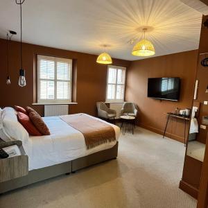 a bedroom with a bed and a flat screen tv at Hues - Castle Cary in Castle Cary