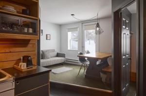 a kitchen with a table and a dining room at Balnea Hôtel - Anciennement Beatnik Hôtel in Bromont