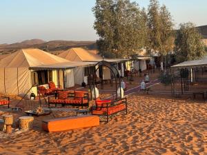 a group of tents in the middle of a desert at Zahra Luxury Desert Camp in Merzouga