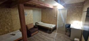 a small room with a bed and a chair at Attic rooms-Bēniņu istabas in Jelgava