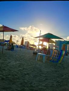 a group of chairs and umbrellas on a beach at Ap Orla de Aracaju in Aracaju