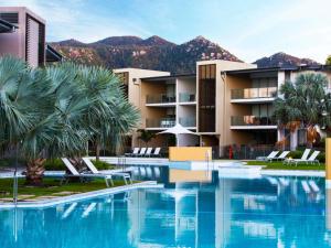 a resort with a pool and palm trees and mountains at Peppers Blue on Blue in Nelly Bay +184 photos