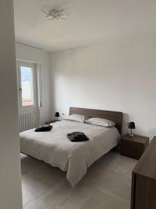 a white bedroom with a large bed and a window at Lake at Home in Lecco +31 photos