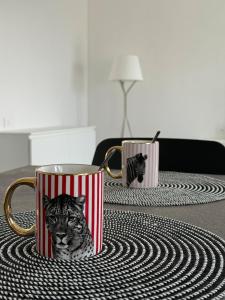 two coffee cups with a cat in them on a table at Lake at Home in Lecco